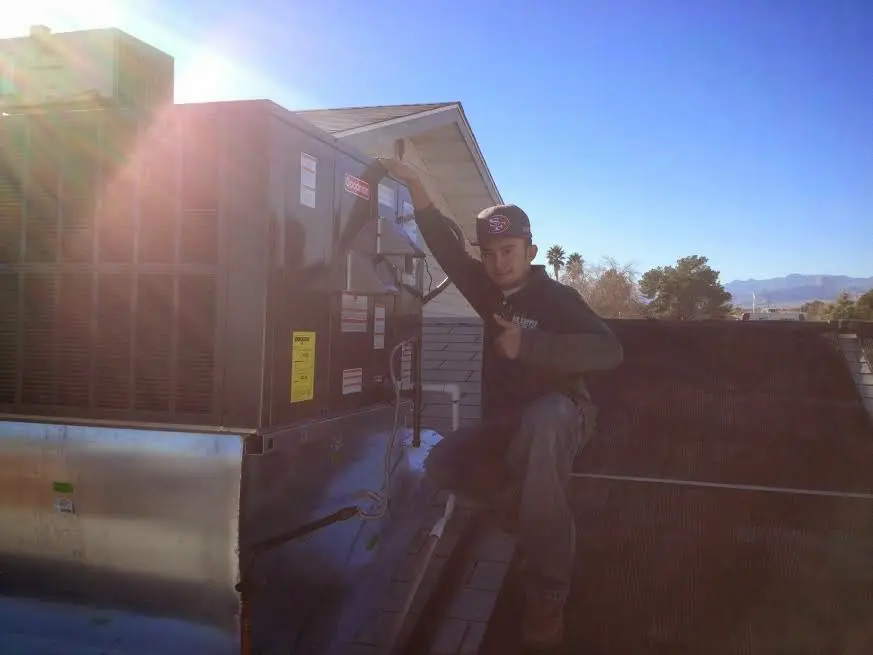 HVAC technician performing AC Tune-Up on a rooftop unit in Duluth